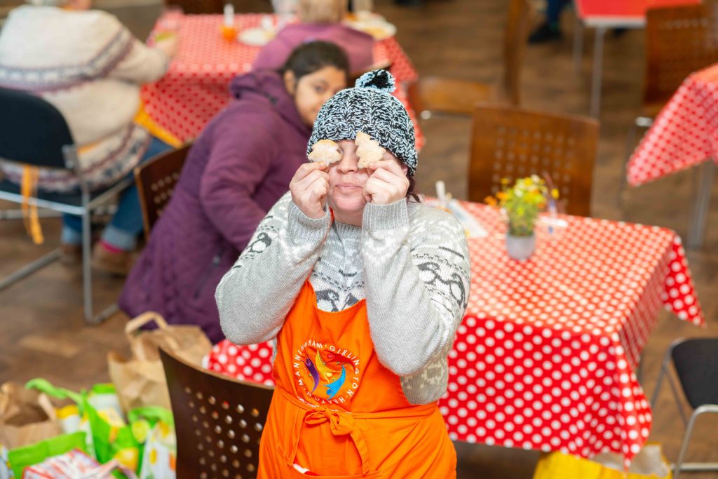 Child holding biscuits over eyes