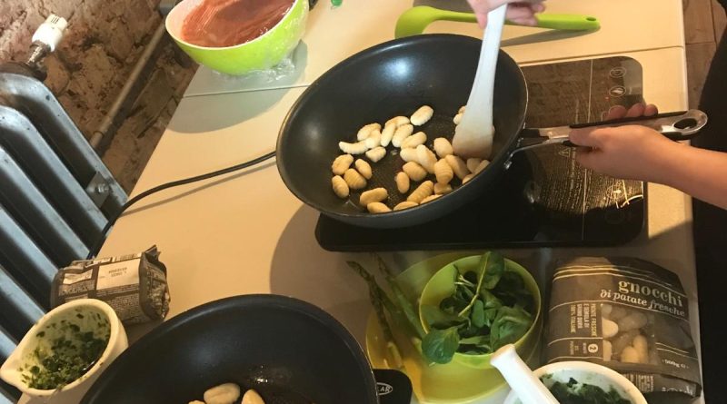 Kids cooking gnocchi in frying pans