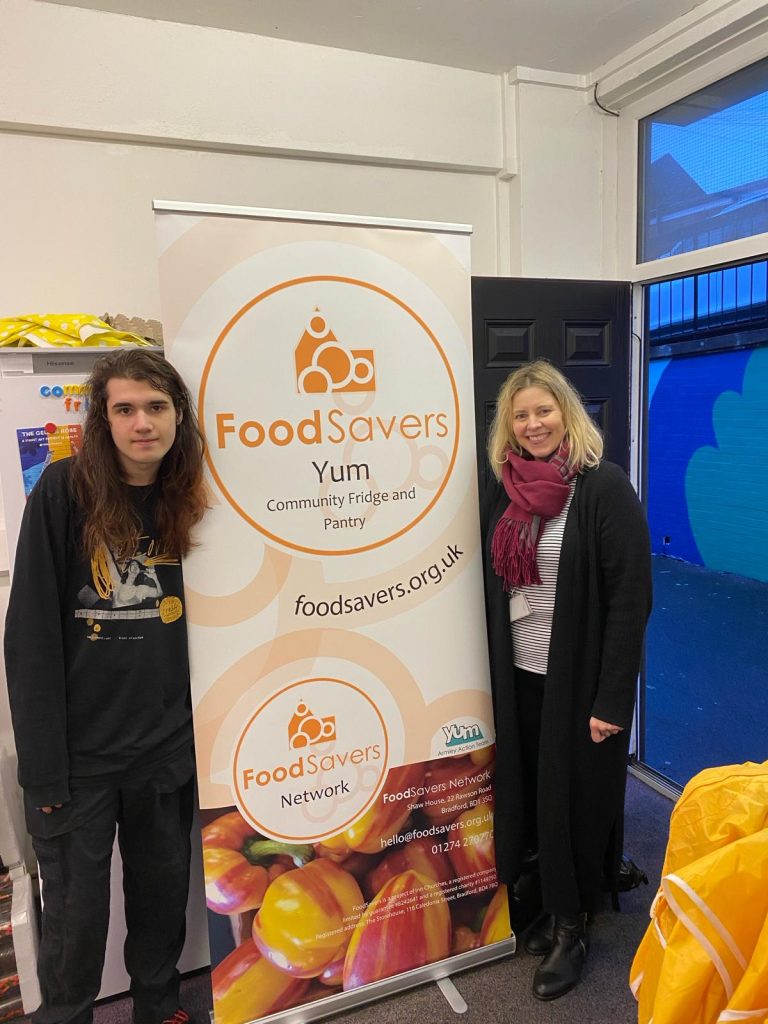 Yum! workers flanking a FoodSavers Yum! banner