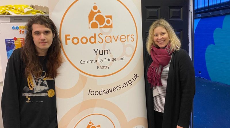 Yum! workers flanking a FoodSavers Yum! banner