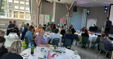 The audience watches from round tables at the Food for Health not Wealth conference