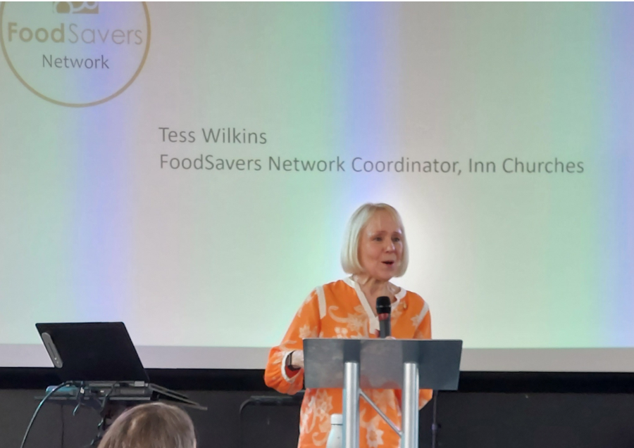 Tess Wilkins speaks at a podium at the Food for Health not Wealth conference