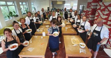 A group of cooks show off their pasta dishes
