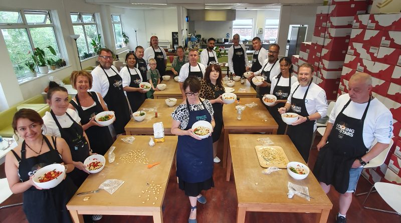 A group of cooks show off their pasta dishes