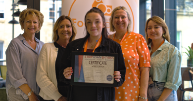 Members of the FoodSavers team hold a certificate recognising official accreditation by Stop Loan Sharks