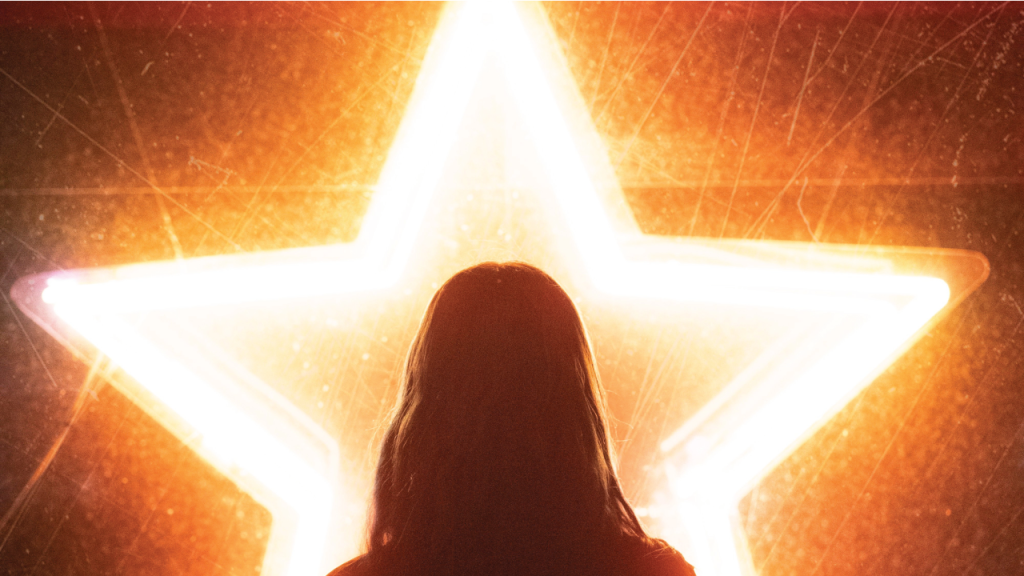 Silhouette of a woman in front of a neon star